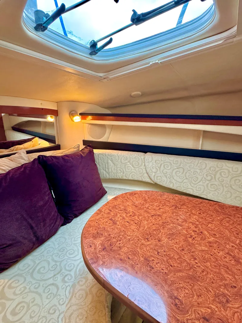Slide: The Image of Interior of 2005 Sea Ray Sundancer 260 with wood table and purple cushions. - 35