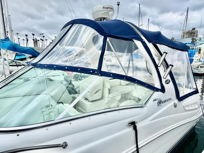 Slide: The Image of 2005 Sea Ray Sundancer 260 with blue cover in marina. - 4