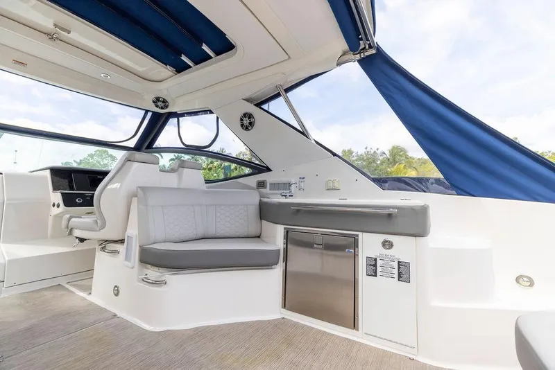 Slide: The Image of 2020 Sea Ray Sundancer 320 interior with seating and kitchenette, featuring modern design elements. - 17