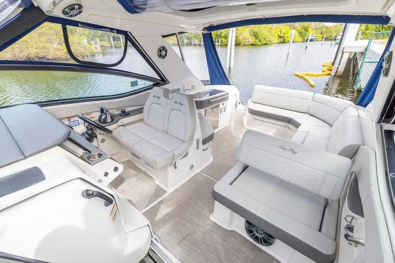 Slide: The Image of 2020 Sea Ray Sundancer 320 interior with plush seating and modern helm, docked by a serene lake. - 18