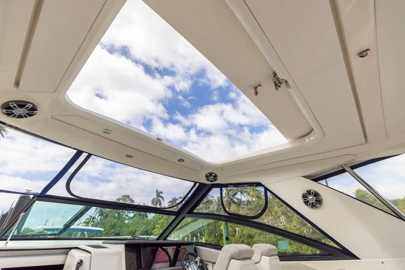 Slide: The Image of Interior view of 2020 Sea Ray Sundancer 320 with open sunroof and clear sky. - 32