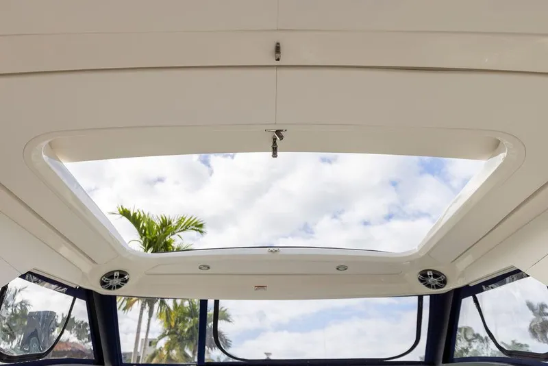 Slide: The Image of Interior view of 2020 Sea Ray Sundancer 320 boat's sunroof with sky and palm trees visible. - 33