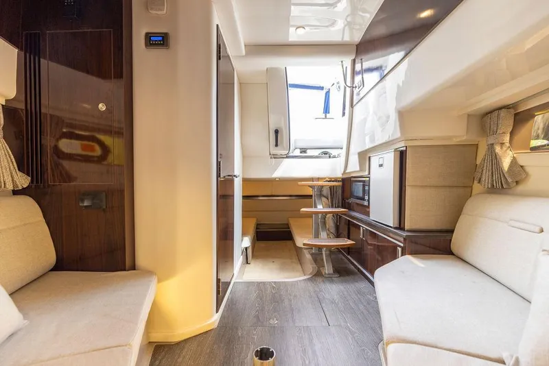 Slide: The Image of Interior of 2020 Sea Ray Sundancer 320 yacht, featuring modern seating and compact kitchen area. - 43