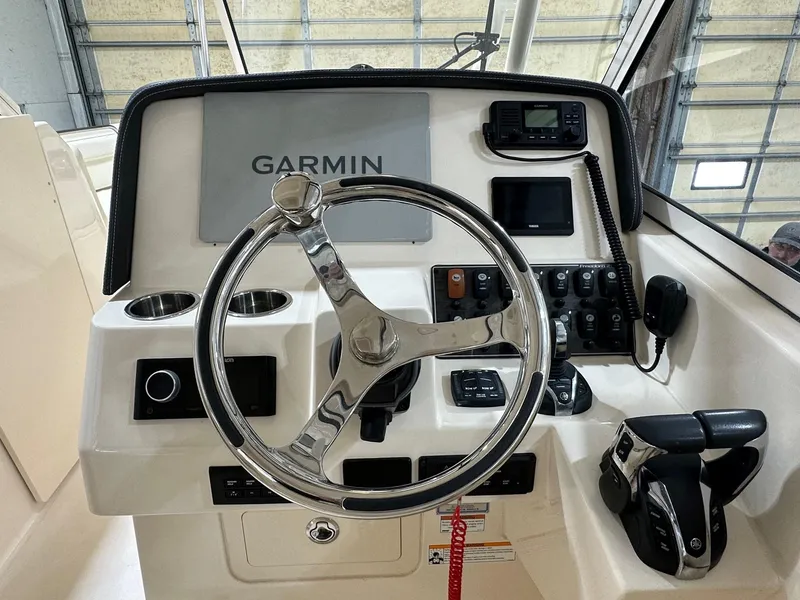 Slide: The Image of 2022 Grady-White Freedom 285 boat dashboard with Garmin navigation system and steering wheel. - 3