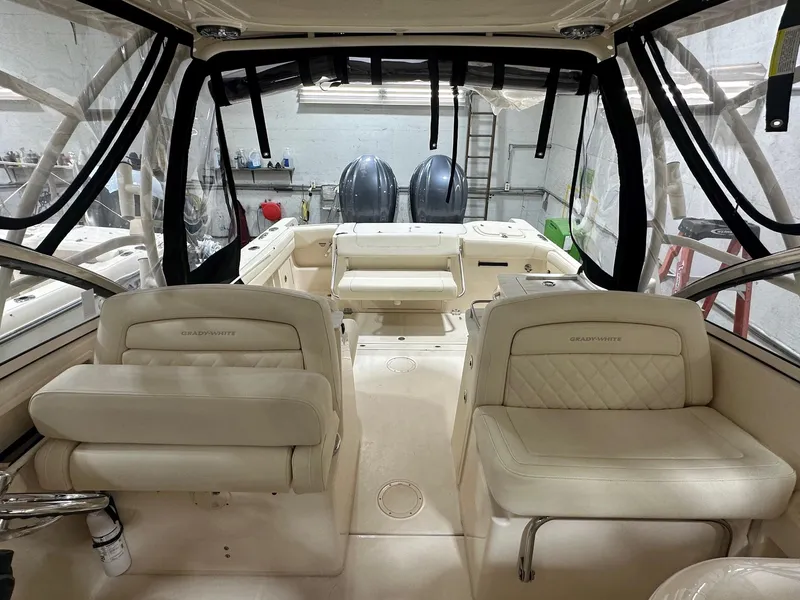 Slide: The Image of 2022 Grady-White Freedom 285 boat interior with seating and dual engines in a garage. - 4