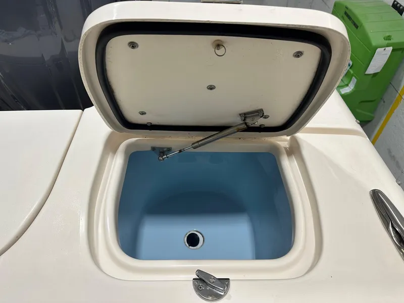 Slide: The Image of Open storage compartment on 2022 Grady-White Freedom 285 boat, featuring a blue interior. - 5