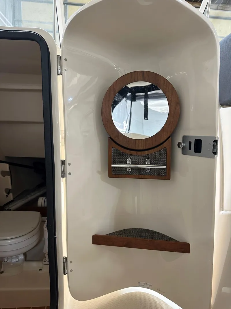 Slide: The Image of 2022 Grady-White Freedom 285 boat interior with round mirror and storage compartments. - 7
