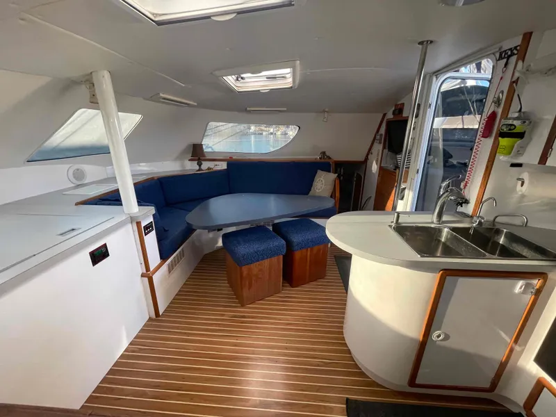 Slide: The Image of Interior of 2000 Manta 42 Catamaran with seating, table, and kitchenette. - 11