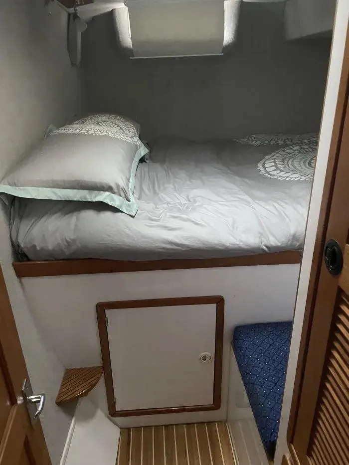 Slide: The Image of Cozy bedroom in 2000 Manta 42 Catamaran with neatly made bed and wooden accents. - 13