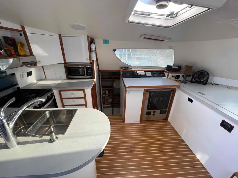 Slide: The Image of Interior of 2000 Manta 42 Catamaran with modern kitchen and wooden flooring. - 15