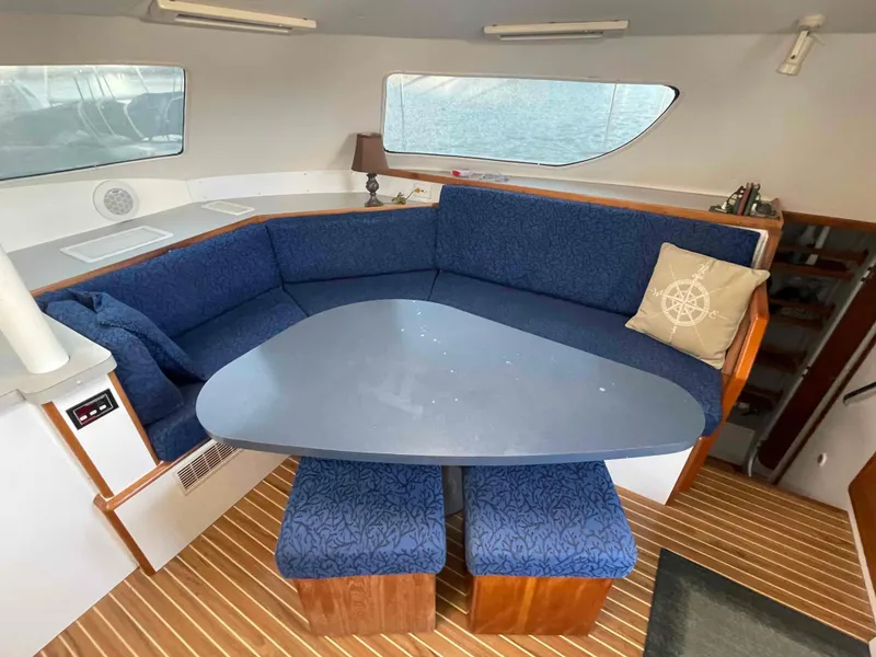 Slide: The Image of Interior of 2000 Manta 42 Catamaran with blue seating and wooden accents. - 22