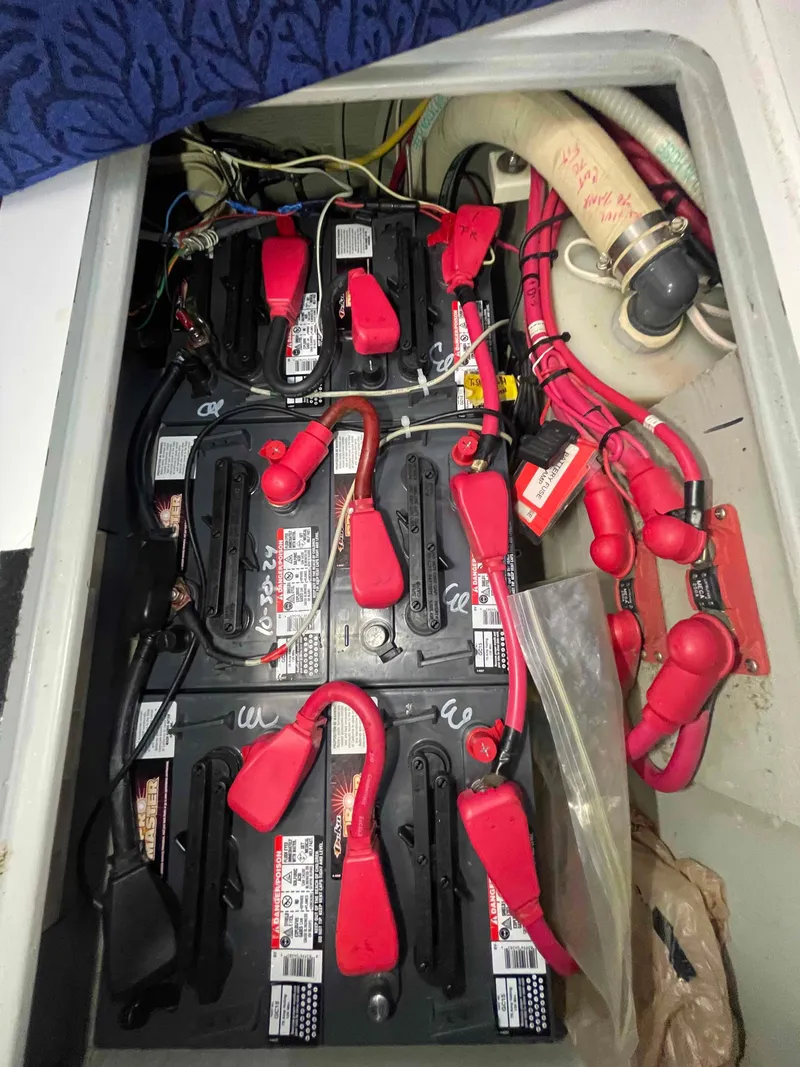 Slide: The Image of Battery compartment of a 2000 Manta 42 Catamaran with red cables and connectors. - 24