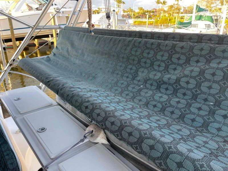 Slide: The Image of Manta 42 Catamaran 2000 with patterned cover, docked at marina, sunny day. - 46