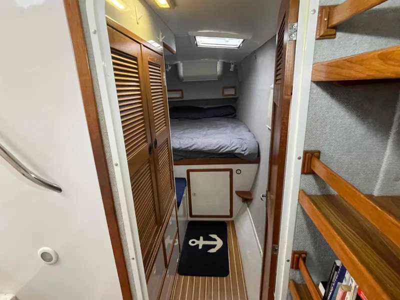 Slide: The Image of Interior of 2000 Manta 42 Catamaran cabin with bed, wooden shelves, and nautical decor. - 6