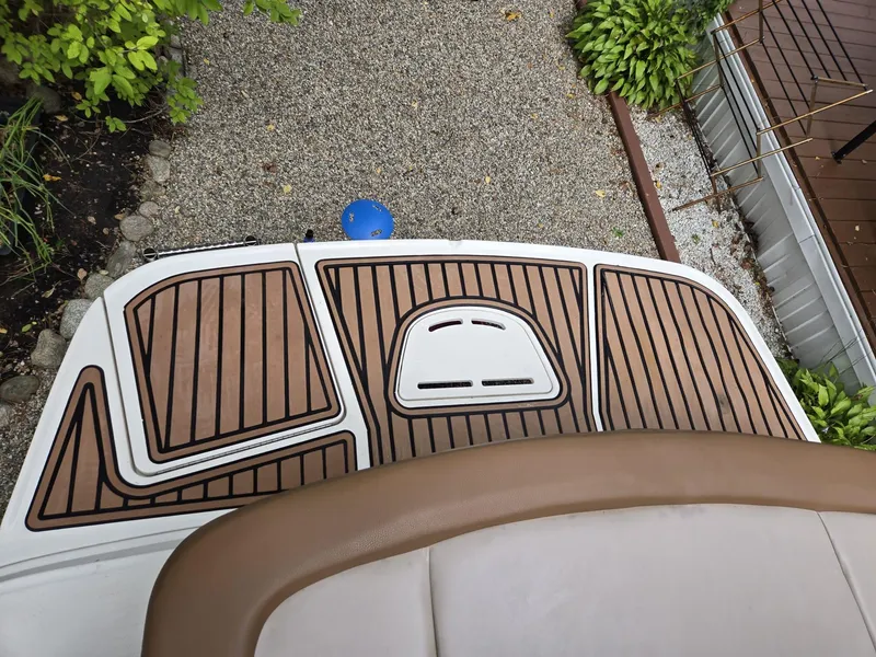 Slide: The Image of 2015 Sea Ray 220 Sundeck boat deck with brown and white detailing. - 16