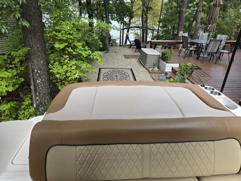 Slide: The Image of 2015 Sea Ray 220 Sundeck boat seat with wooded backyard view. - 18