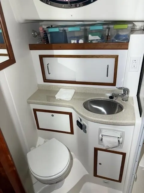 Slide: The Image of 2013 Back Cove 34 yacht bathroom with sink, toilet, and storage cabinets. - 13