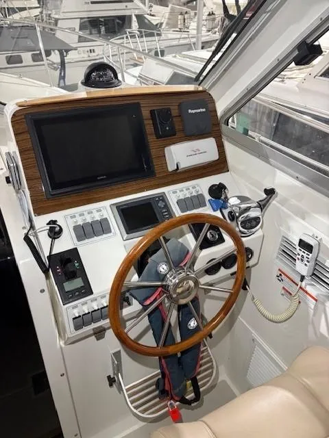 Slide: The Image of 2013 Back Cove 34 helm with wooden steering wheel and navigation equipment. - 3