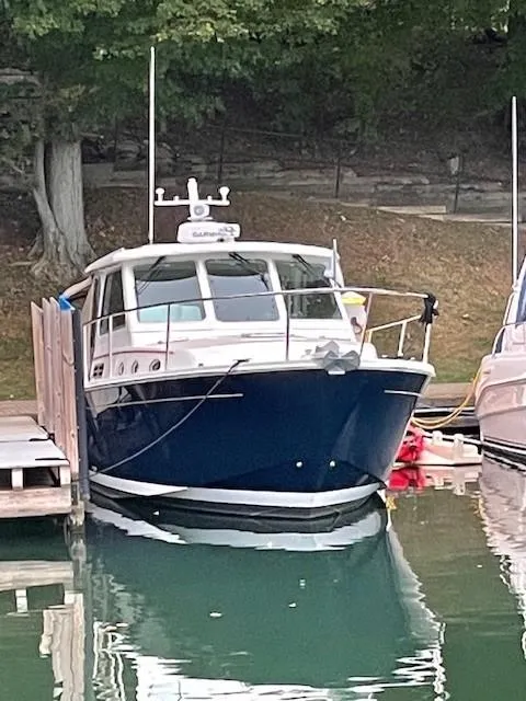 Slide: The Image of 2013 Back Cove 34 boat docked in a serene marina setting. - 5