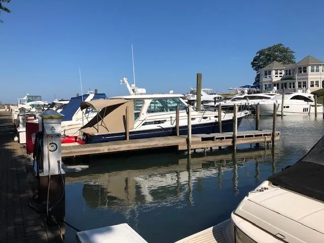 Slide: The Image of 2013 Back Cove 34 yacht docked at marina, clear blue sky, waterfront view. - 7
