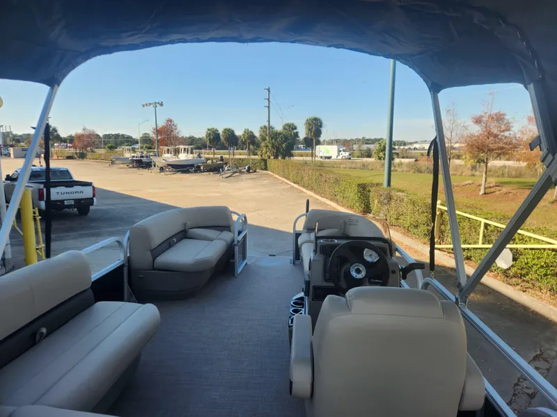 Slide: The Image of 2025 Sun Tracker Party Barge 16 DLX interior with seating and steering console. - 3