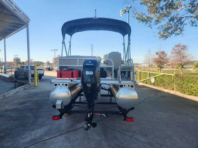 Slide: The Image of 2025 Sun Tracker Party Barge 16 DLX pontoon boat with 50 HP engine, parked outdoors. - 5