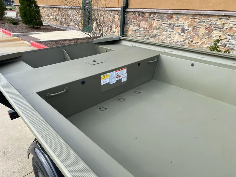 Slide: The Image of 2025 Tracker Grizzly 1754 Jon boat interior, olive green, parked outdoors. - 5