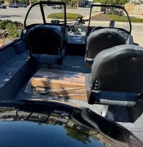 Slide: The Image of 2025 Tracker Pro Guide V-16 WT boat interior with seating and dashboard view. - 2