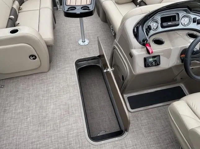 Slide: The Image of 2023 Sun Tracker Party Barge 22 RF XP3 interior with open storage compartment and beige seating. - 14