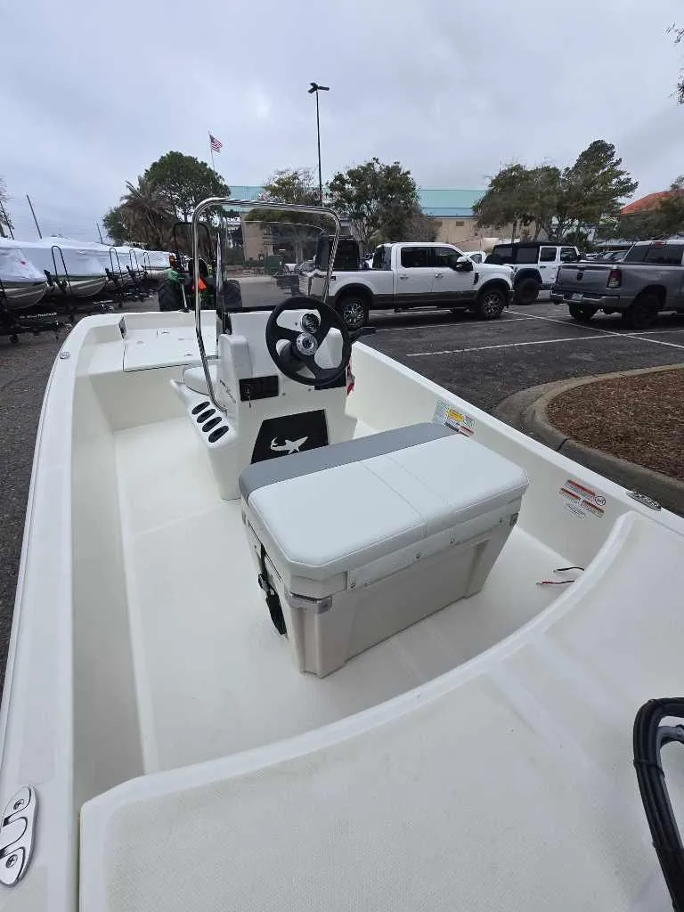 Slide: The Image of 2025 Mako Pro Skiff 15 CC boat with center console in a parking lot. - 3