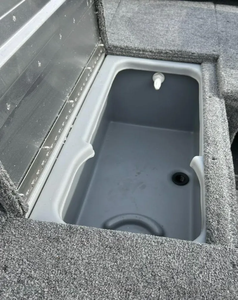 Slide: The Image of 2025 Tracker Pro 170 boat storage compartment with gray interior and textured exterior. - 12