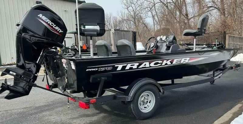 Slide: The Image of 2025 Tracker Pro 170 boat with Mercury engine, parked outdoors on a trailer. - 3