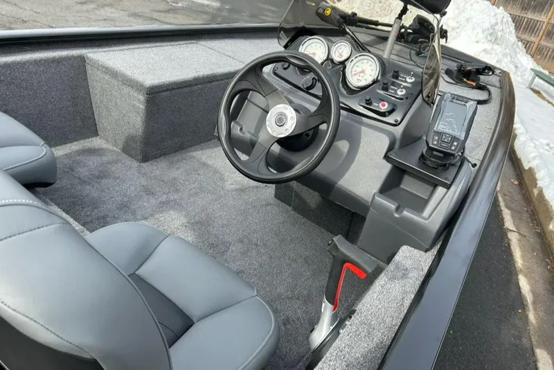 Slide: The Image of 2025 Tracker Pro 170 boat interior with steering wheel, gauges, and gray seating. - 9