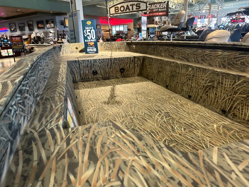 Slide: The Image of 2025 Tracker Grizzly 1650 T Prairie Wings Edition boat with camo design in showroom. - 3