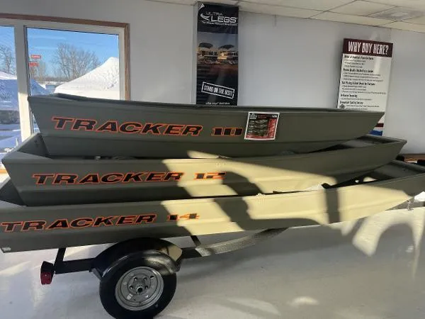 The Image of 2025 Tracker Grizzly 1236 Utility boats stacked in showroom, showcasing durable design. - 0