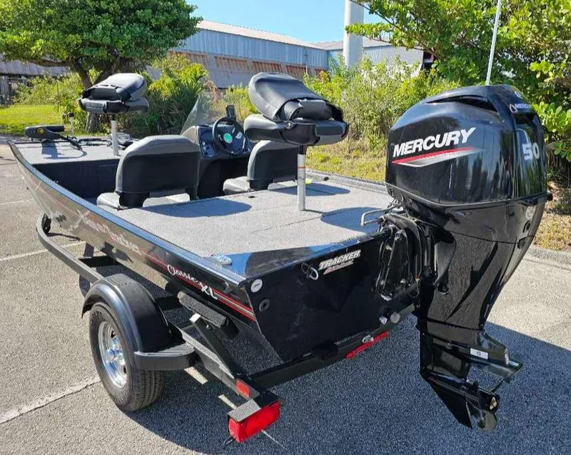 Slide: The Image of 2025 Tracker Bass Tracker Classic XL boat with Mercury 50 engine, parked outdoors. - 8