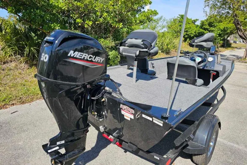 Slide: The Image of 2025 Tracker Bass Tracker Classic XL boat with Mercury engine, parked outdoors. - 9