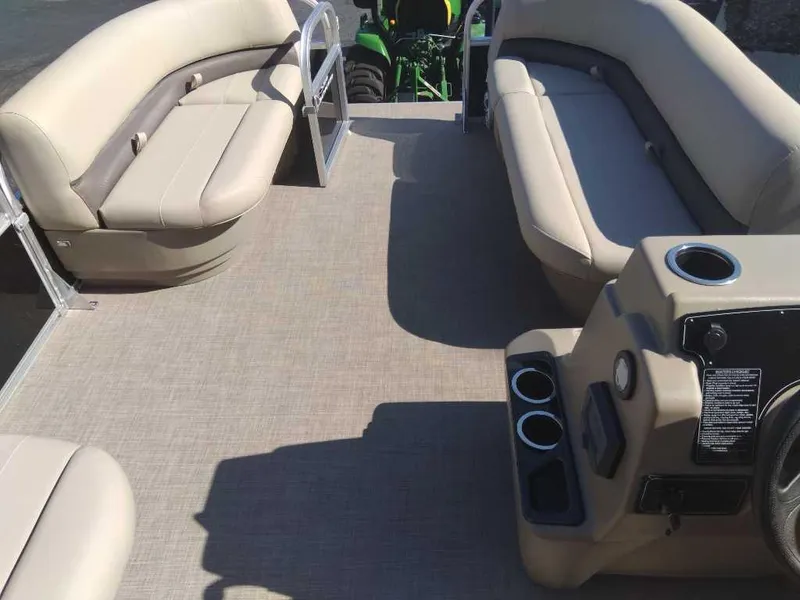 Slide: The Image of 2025 Sun Tracker Party Barge 16 DLX interior with beige seating and cup holders. - 4