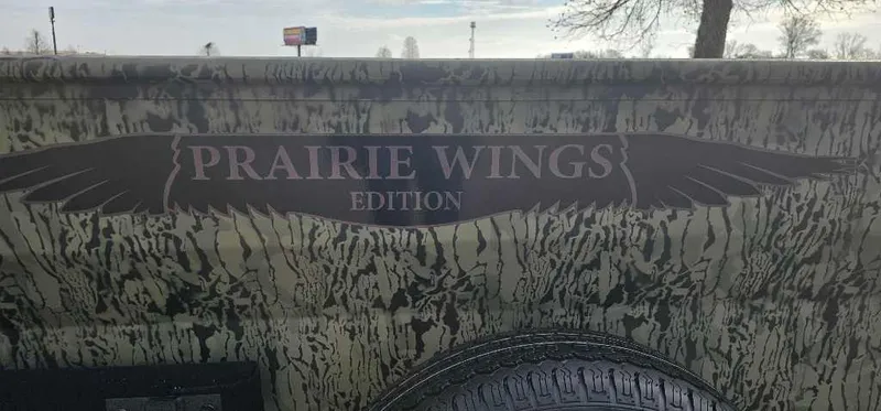 Slide: The Image of 2025 Tracker Grizzly 1650 T Prairie Wings Edition with camouflage design and logo. - 2