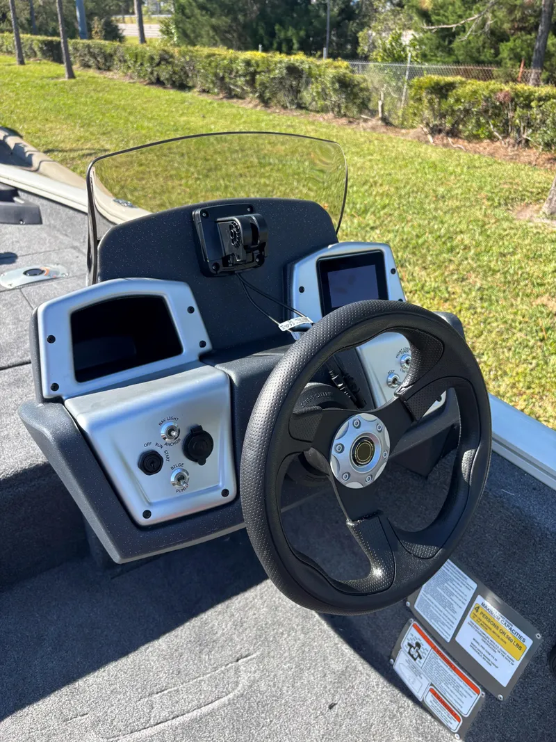 Slide: The Image of 2025 Tracker Pro Team 175 Crappie Edition boat dashboard with steering wheel and controls. - 2