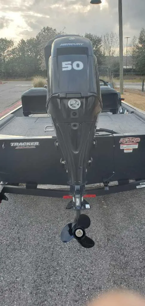 Slide: The Image of 2025 Tracker Bass Tracker Classic XL boat with 50 HP motor, parked outdoors. - 2
