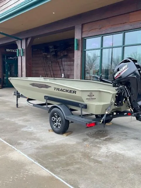 Slide: The Image of 2025 Tracker Grizzly 1650 T Prairie Wings Edition boat on trailer, parked outside a building. - 2