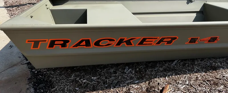 Slide: The Image of 2025 Tracker Grizzly 1436 Utility boat with bold orange lettering on the side. - 2