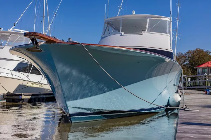Slide: The Image of Custom Carolina 66 yacht, 2005 model, docked in a marina under clear blue skies. - 18