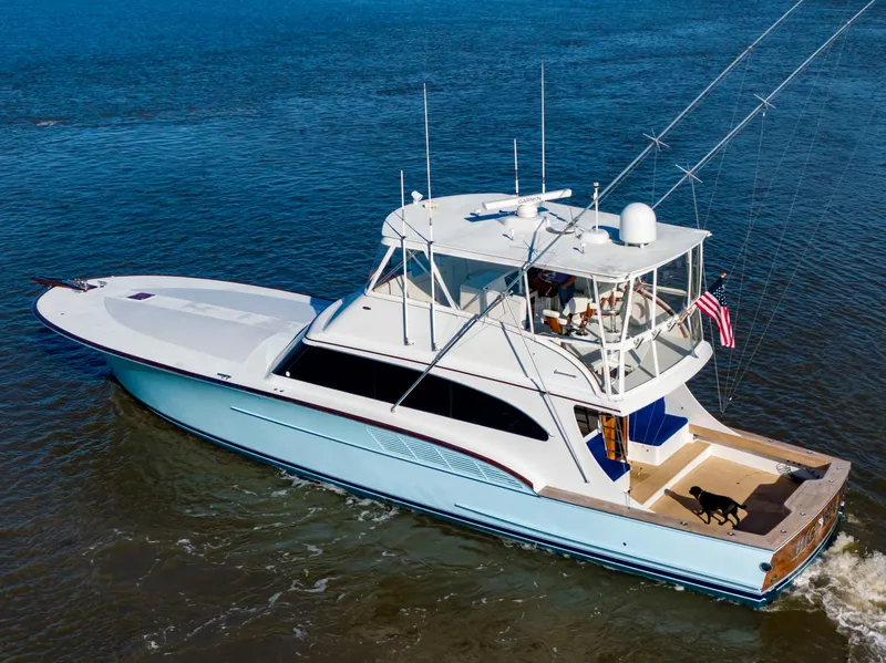 Slide: The Image of 2005 Custom Carolina 66 yacht cruising on water, featuring a sleek design and spacious deck. - 2