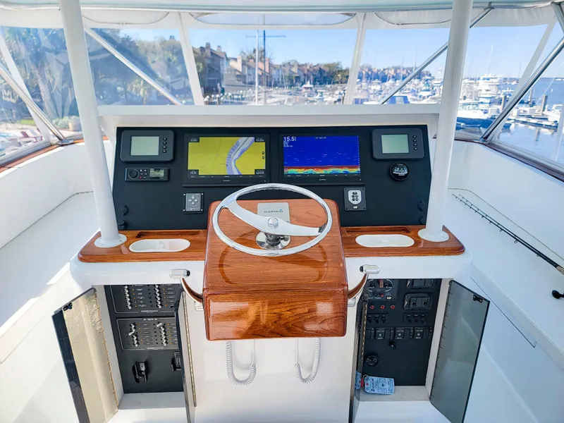 Slide: The Image of Helm of 2005 Custom Carolina 66 yacht with navigation screens and wooden steering wheel. - 21