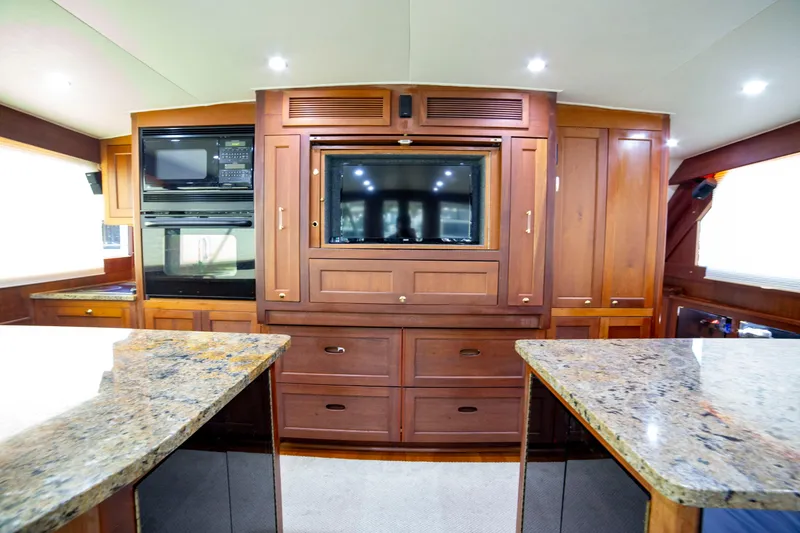 Slide: The Image of Luxurious interior of 2005 Custom Carolina 66 yacht with wood cabinetry and granite countertops. - 31