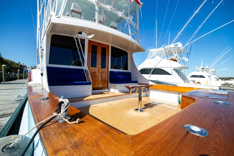 Slide: The Image of Custom Carolina 66 yacht, 2005 model, docked with polished wood deck and blue seating. - 36