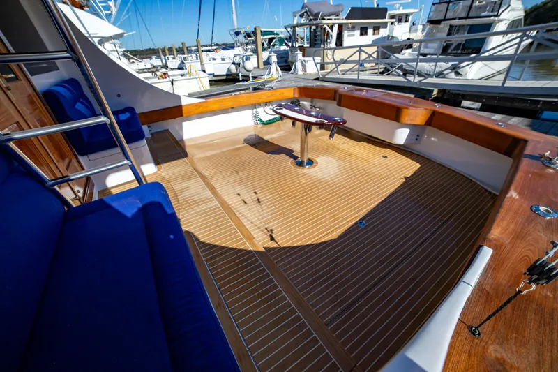 Slide: The Image of Spacious deck of 2005 Custom Carolina 66 yacht with wooden flooring and blue seating. - 38