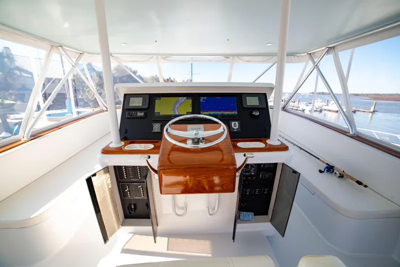 Slide: The Image of Helm of 2005 Custom Carolina 66 yacht with navigation screens and wooden steering wheel. - 41